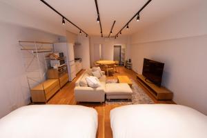 uma sala de estar com duas camas e uma mesa em NIYS apartments 08 type em Tóquio