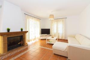 ein Wohnzimmer mit einem Sofa und einem Kamin in der Unterkunft VILLA ANDALUCÍA: cerca de todo, intimidad y espacio in Nerja