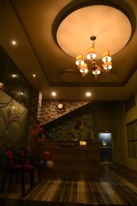 sala de estar con techo con lámpara de araña en URBAN COTTAGE, en Guwahati