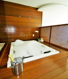 a bath tub in a room with a wooden wall at Oasis Cabo Frio in Cabo Frio
