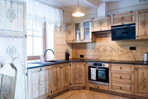 uma grande cozinha com armários de madeira e uma janela em Chaty Mocarnego Szaflary em Szaflary