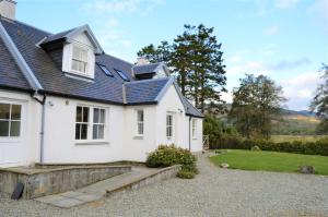 a white house with a blue roof at Shelduck Cottage in Feorlean