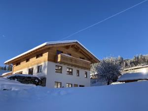een huis in de sneeuw op een berg bij Ferienwohnung Helchenberg in Bad Hindelang