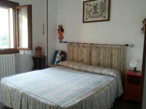 een slaapkamer met een bed met een gestreepte deken bij Tuscany Holiday Home in Porretta Terme +33 foto's