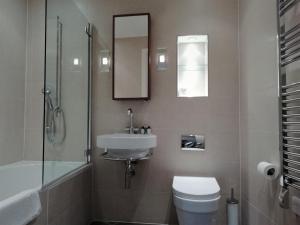 a bathroom with a toilet and a sink and a shower at Barbican Serviced Apartments in London