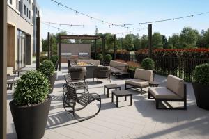 un patio con sillas, mesas y una hoguera en Staybridge Suites Charlotte Arpt Area - Tyvola by IHG, en Charlotte