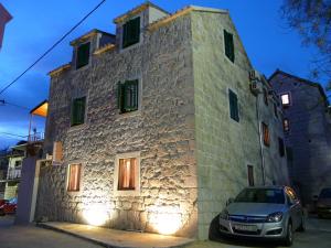 une voiture garée devant un bâtiment en pierre avec des lumières dans l'établissement House Sandra, à Split