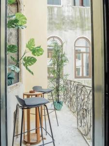 a balcony with two stools and two windows at Venice Palace Tintoretto by Wonderful Italy in Venice