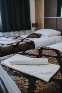 um grupo de camas alinhadas em fila em Hotel Brcko Gas Doboj em Doboj
