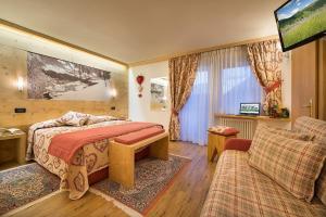 sypialnia z łóżkiem i kanapą w obiekcie Hotel Bucaneve w Livigno