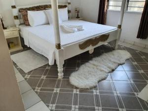 a bedroom with a bed and a white rug at Nyumba Tulivu in Watamu