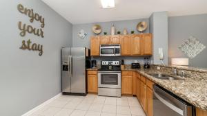 a kitchen with stainless steel appliances and wooden cabinets at 5 Star Townhome on Windsor Hills Resort with Large Private Pool, Orlando Townhome 4922 in Orlando