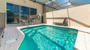 a swimming pool with a table and chairs in a house at 5 Star Townhome on Windsor Hills Resort with Large Private Pool, Orlando Townhome 4922 in Orlando