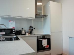 eine Küche mit weißen Schränken und einem Herd mit Backofen in der Unterkunft Leather Lane Serviced Apartments in London