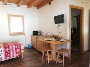 Dormitorio con escritorio, cama y TV en Ai Larici en Perarolo di Cadore