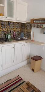 a kitchen with white cabinets and a sink at Résidence LA VILLA in Midoun