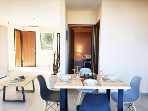 a dining room with a table and blue chairs at Manos Philoxenia in Kriopigi