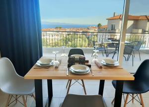 a wooden table and chairs with a view of a balcony at Manos Philoxenia in Kriopigi