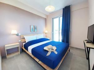 a bedroom with a large blue bed with a hat on it at Manos Philoxenia in Kriopigi