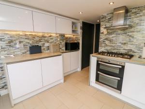 a kitchen with white cabinets and a stove at 5 Lake House in Lancaster