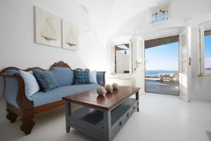 a living room with two couches and a table at Atrina Canava 1894 in Oia