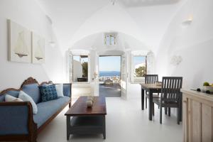 a living room with a blue couch and a table at Atrina Canava 1894 in Oia