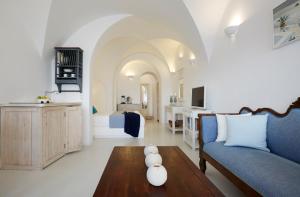 a living room with a blue couch and a table at Atrina Canava 1894 in Oia