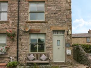 a brick house with a bench and a door at 4 Cherry Tree Cottages in Bradwell