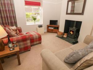 a living room with a couch and a fire place at 4 Cherry Tree Cottages in Bradwell