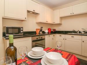 a kitchen with a table with plates and wine glasses at 4 Cherry Tree Cottages in Bradwell