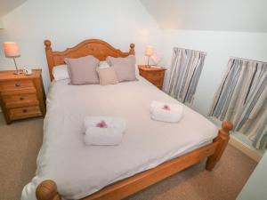 una camera da letto con un grande letto bianco con due cuscini di 4 Cherry Tree Cottages a Bradwell