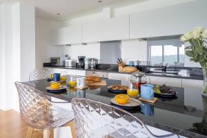 a kitchen with a table with plates of food on it at Newquay Fistral Beach View in Newquay