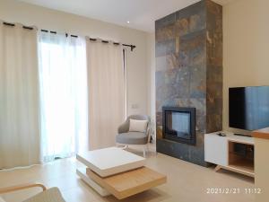 Una sala de estar con un televisor y una silla. en Cozy villa with pool and Barbecue, en Albufeira