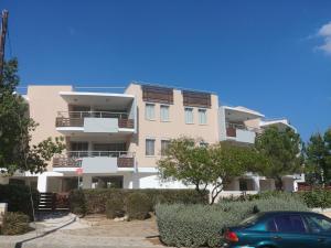 ein Gebäude mit einem davor geparkten Auto in der Unterkunft Amathousa Coastal Heights D202 in Limassol