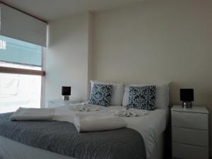 a bedroom with a large bed with pillows and a window at Still Life Old Street Executive in London