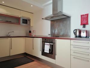 a kitchen with white cabinets and a stove top oven at Still Life Old Street Executive in London