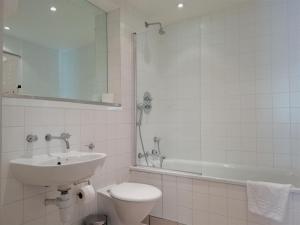 a bathroom with a sink and a toilet and a tub at Still Life Old Street Executive in London