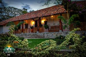 a house with a porch with lights on it at Hotel Parque la Casona in La Jagua de Ibirico