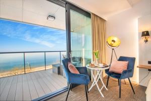 a room with a balcony with a view of the ocean at NORTH Apartments, SunSetView 507 in Kołobrzeg