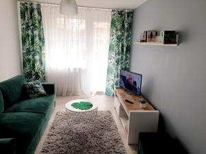 a living room with a green couch and a coffee table at POKOJE GOŚCINNE UZDROVISCO CIEPLICE in Jelenia Góra