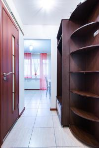 a room with a wooden book shelf next to a door at Studiominsk 8 Apartments in Minsk