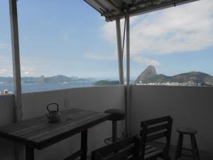 - une table sur un balcon avec vue sur l'océan dans l'établissement Hostel Tavares Bastos, à Rio de Janeiro