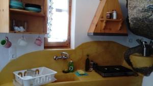 eine Küche mit einer Spüle und einer Theke mit einer Spüle in der Unterkunft Zacharoula Rooms in Manganítis