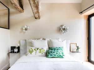 - une chambre avec un lit blanc et des oreillers blancs dans l'établissement Chez Laurence du Tilly - L'annexe, à Colomby-sur-Thaon