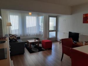 a living room with a couch and a tv at Vakantie Appartementen Engelen in Stevensweert