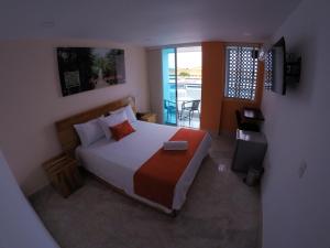 um quarto com uma cama grande e uma varanda em Kamaleb Farallones Hotel em Quibdó