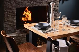 a table with plates and glasses and a fireplace at White Hills Suites & Spa in Arachova