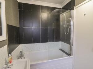 a bathroom with a tub and a sink and a shower at Mollys Cottage in St Just +16 photos