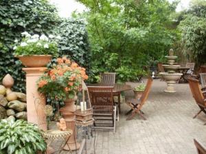 un patio con una mesa, sillas y una fuente. en Hotel am Glockenturm en Lüchow