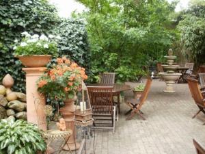 un patio con una mesa, sillas y una fuente. en Hotel am Glockenturm, en Lüchow